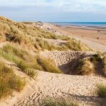 Stroll the dunes and the flat stretches on the miles of Camber Beach